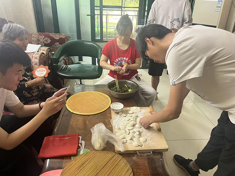 圖為實踐團成員在認真幫助老人做飯包餃子的日常團隊成員攝